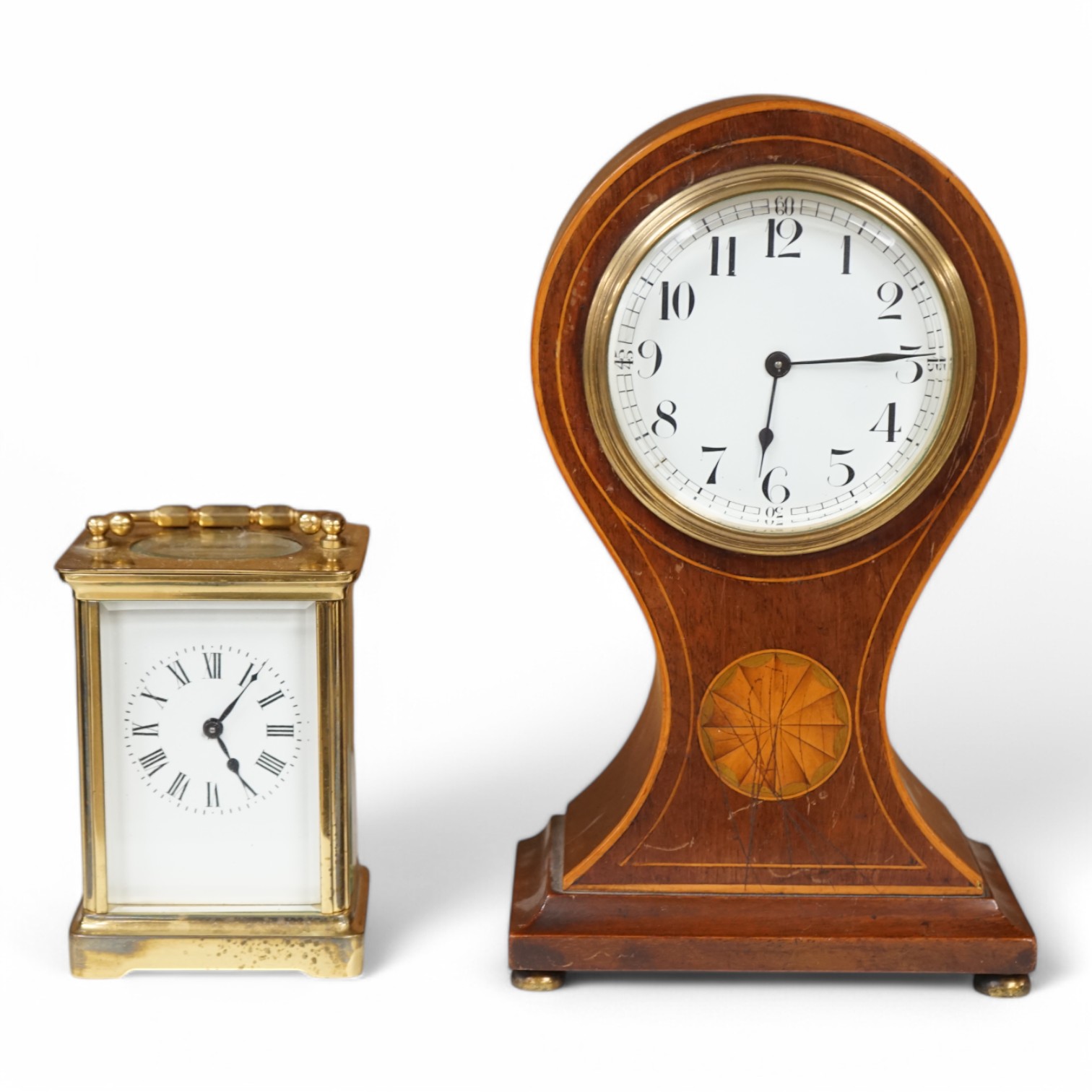 An Edwardian inlaid mahogany balloon clock and a brass cased carriage timepiece, largest 23cm high. Condition - fair, untested